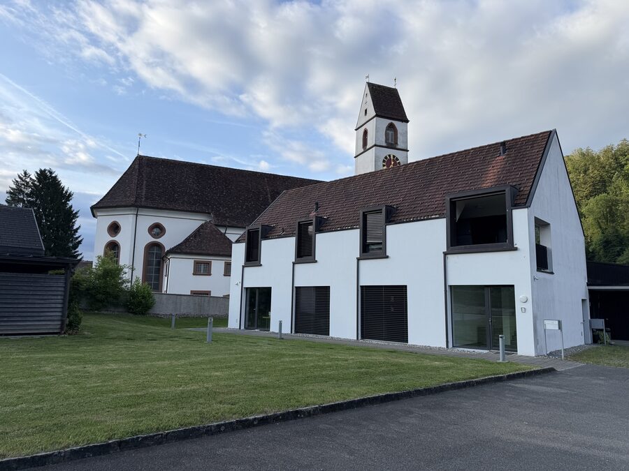Barocke römisch-katholische Pfarrkirche St. Remigius mit modernem Pfarrhaus und Versammlungssaal im Mettauertal