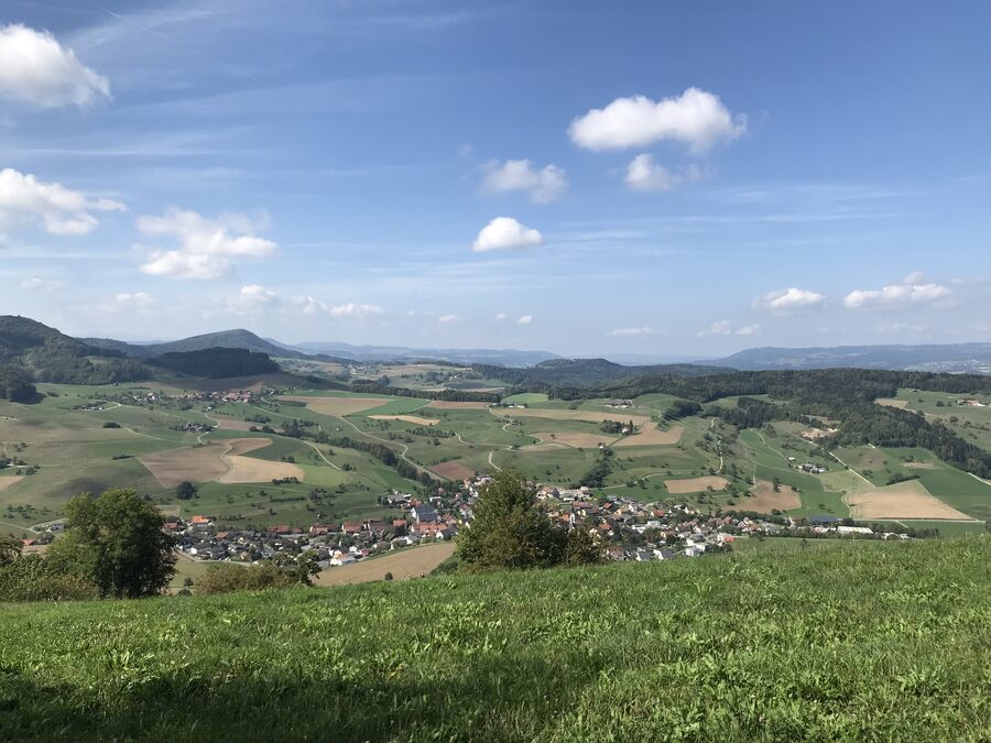 offene Landschaft mit abgeernteten Getreidefeldern, Blick nach Westen über Gansingen und den Weiler Galten bis zu den Höhenzügen des Sulztals und dem Schwarzwald im Hintergrund