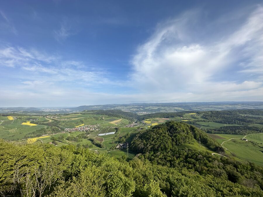 Landschaft mit Blick vom Cheisacherturm auf das landwirtschaftliche Sulztal und das Industriegebiet Stein, dahinter der bewaldete Schwarzwald